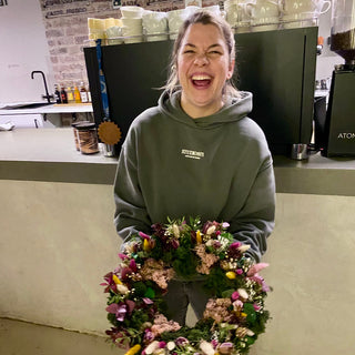 Lachens Workshopteilnehmerin mit ihrem Adventkranz in grün, gelb lila