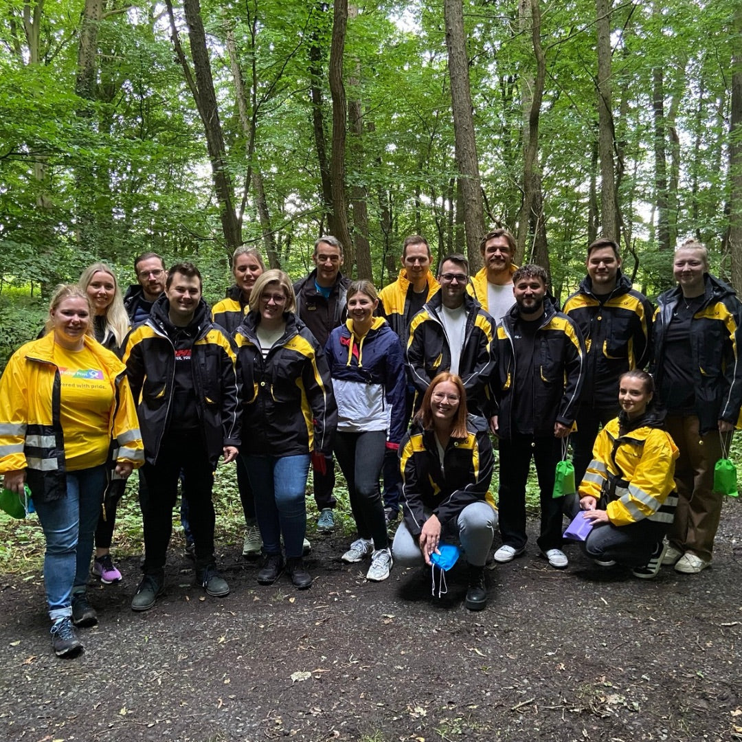 16 Mitarbeiter:innen der Post bei einem Waldbade Workshop im Wald in Münster. 
