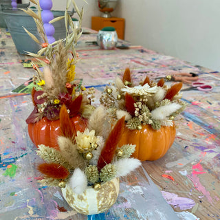 Drei dekorierte Kürbisse (2 orange Kunstkürbisse Ø9,5cm, 1 getrockneter Mini-Kürbis) mit bunten,herbstlichen Trockenblumen als herbstliche DIY-Deko für Workshop in Münster.