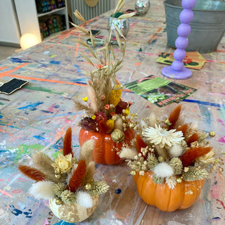 Herbstliche DIY-Dekoration: Zwei orange Kunstkürbisse und ein getrockneter Mini-Kürbis, kunstvoll mit Trockenblumen verziert als herbstliche DIY-Deko für Workshop in Münster.