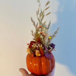Herbstliche DIY-Dekoration: ein dunkel orange Kunstkürbisse kunstvoll mit Trockenblumen verziert für Workshop in Münster.