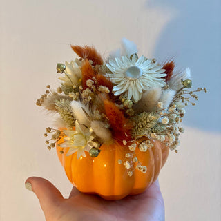 Herbstliche DIY-Dekoration: ein orange Kunstkürbisse kunstvoll mit Trockenblumen verziert für Workshop in Münster.