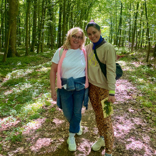 Mutter und Tochter stehen Arm in Arm und lächeln in die Kamera beim Waldbaden in Münster.